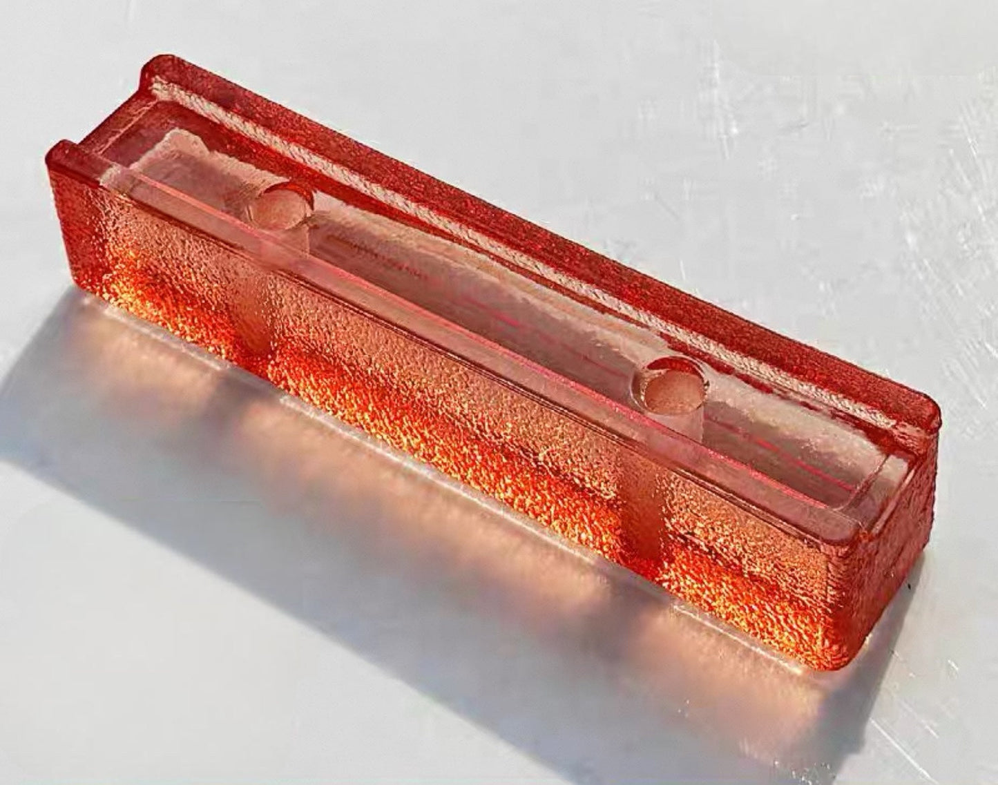 Perforated Orange Peel Aperol glass brick with vibrant dimpled texture by MIOLISM