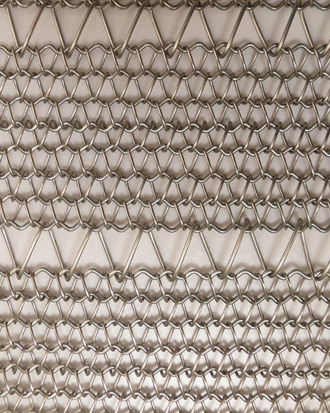 Close-up of a textured metal mesh with a diamond pattern.