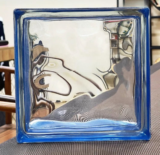 Glass block with a blue frame reflecting indoor furniture