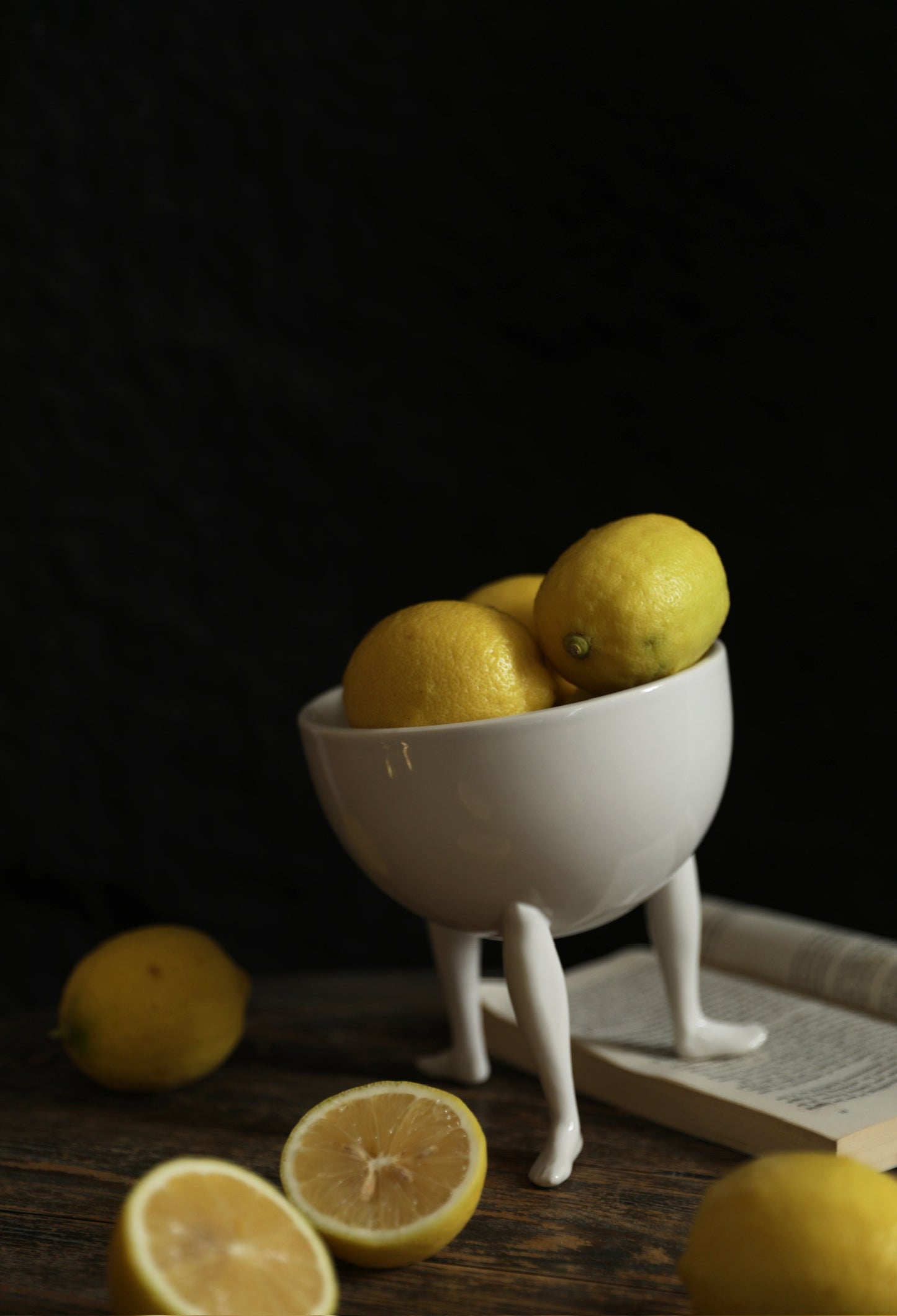 3-Legged Ceramic Fruit Bowl with lemons on a book