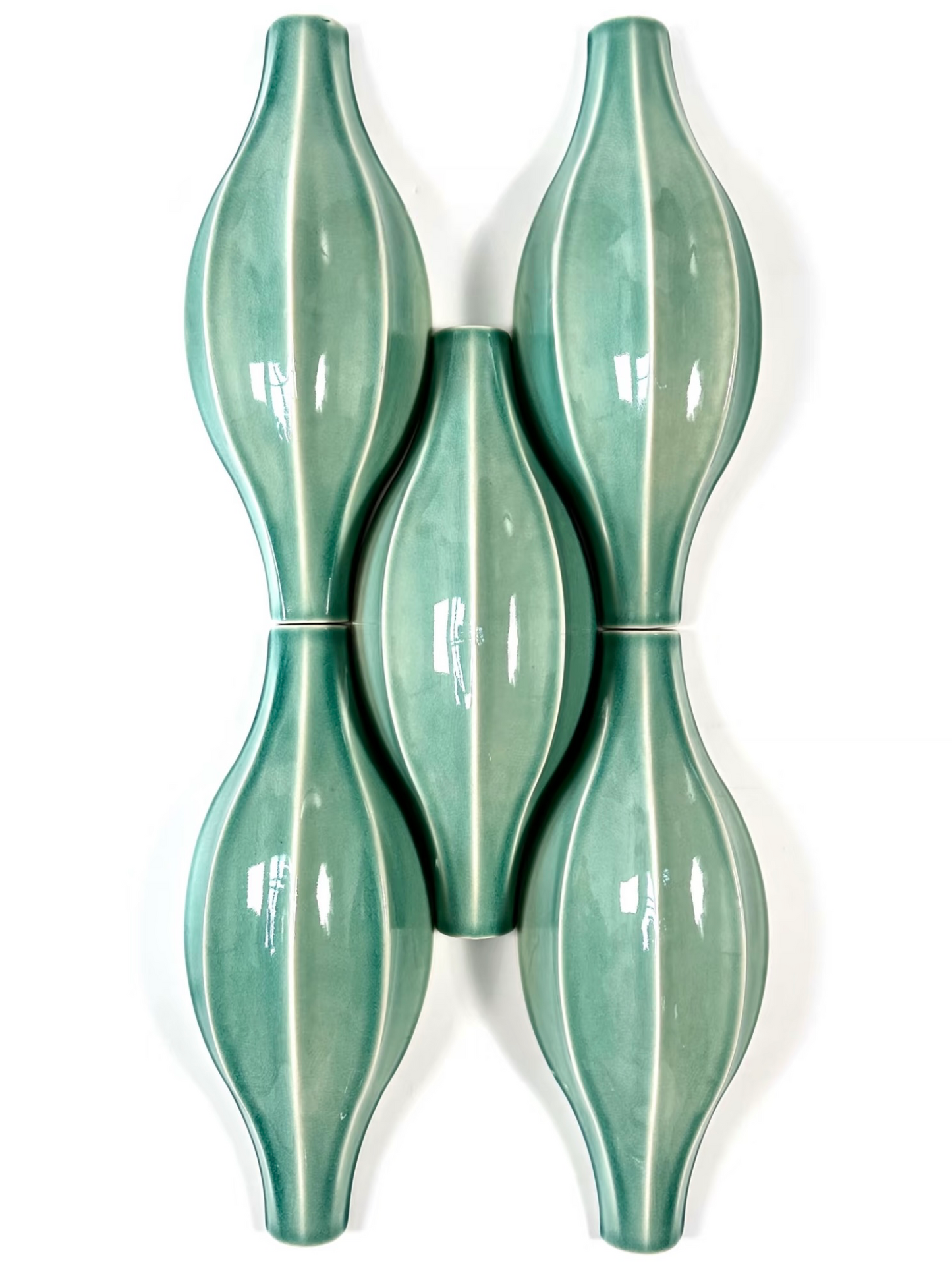 Two green ceramic wall sconces on a white background