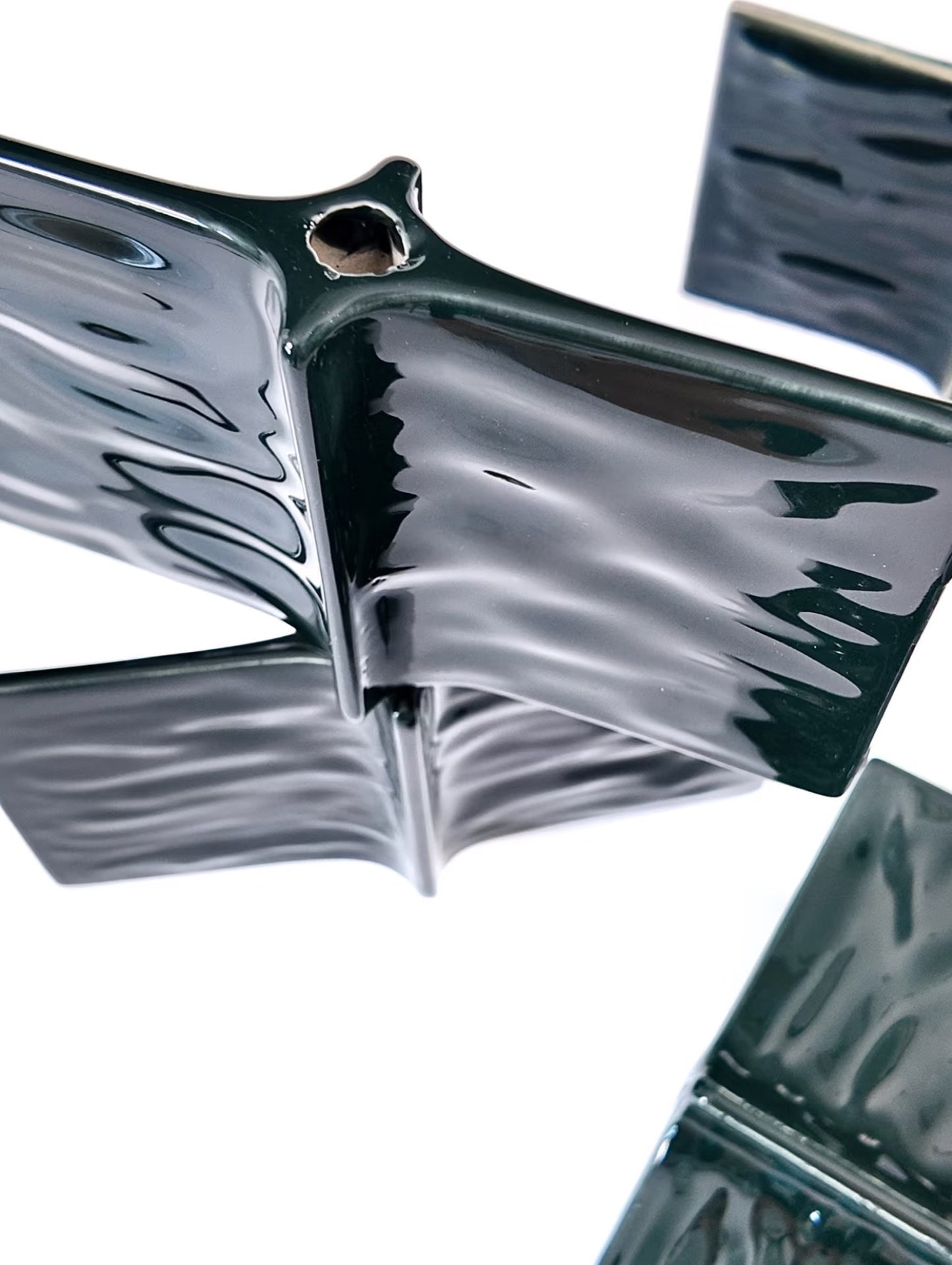 Metallic butterfly-shaped object on a white background