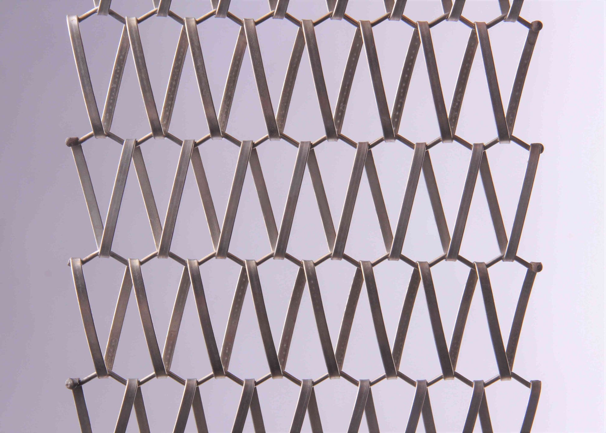 Metallic mesh pattern on a light gray background