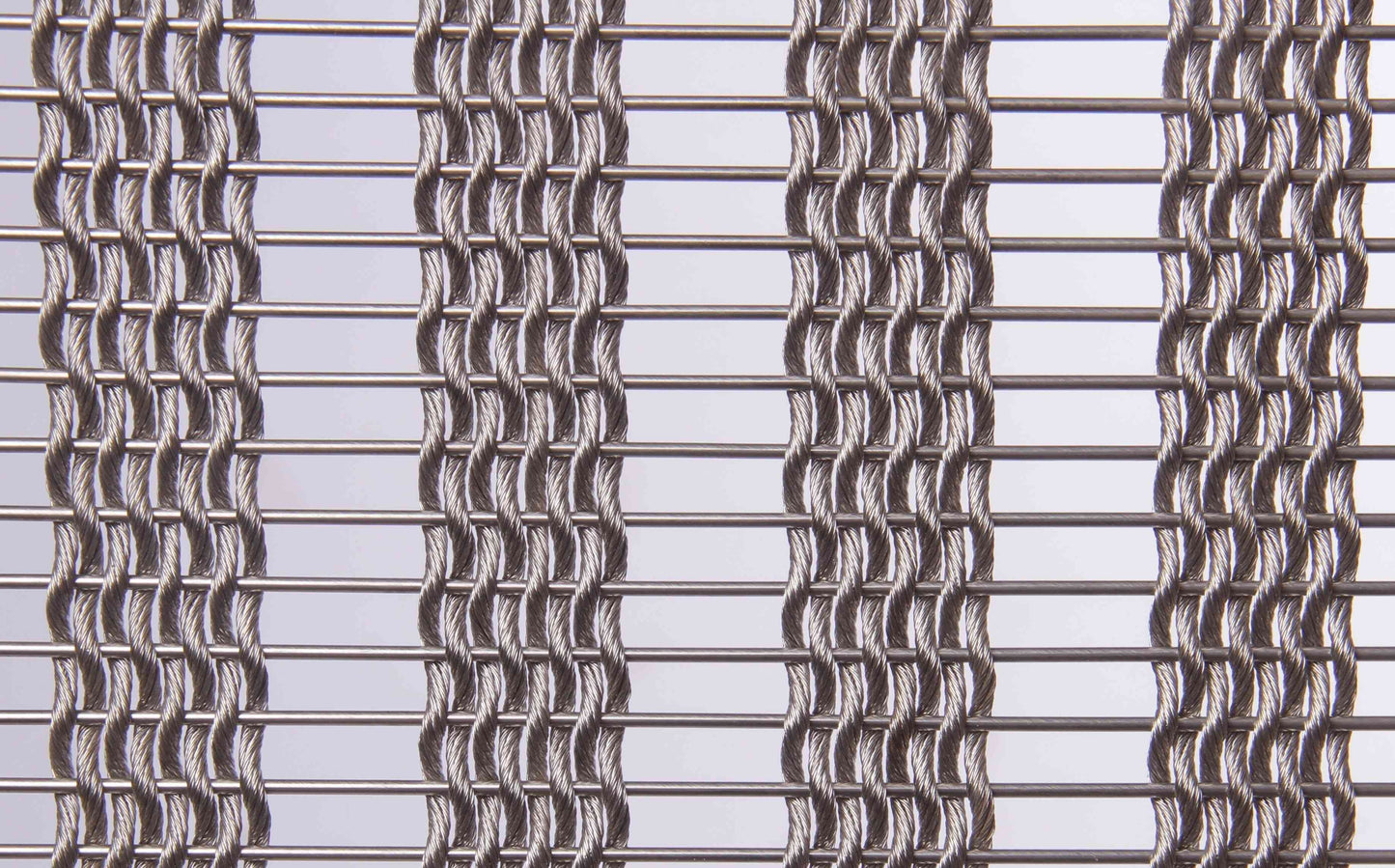 Close-up of a metal wire mesh with a grid pattern on a light gray background