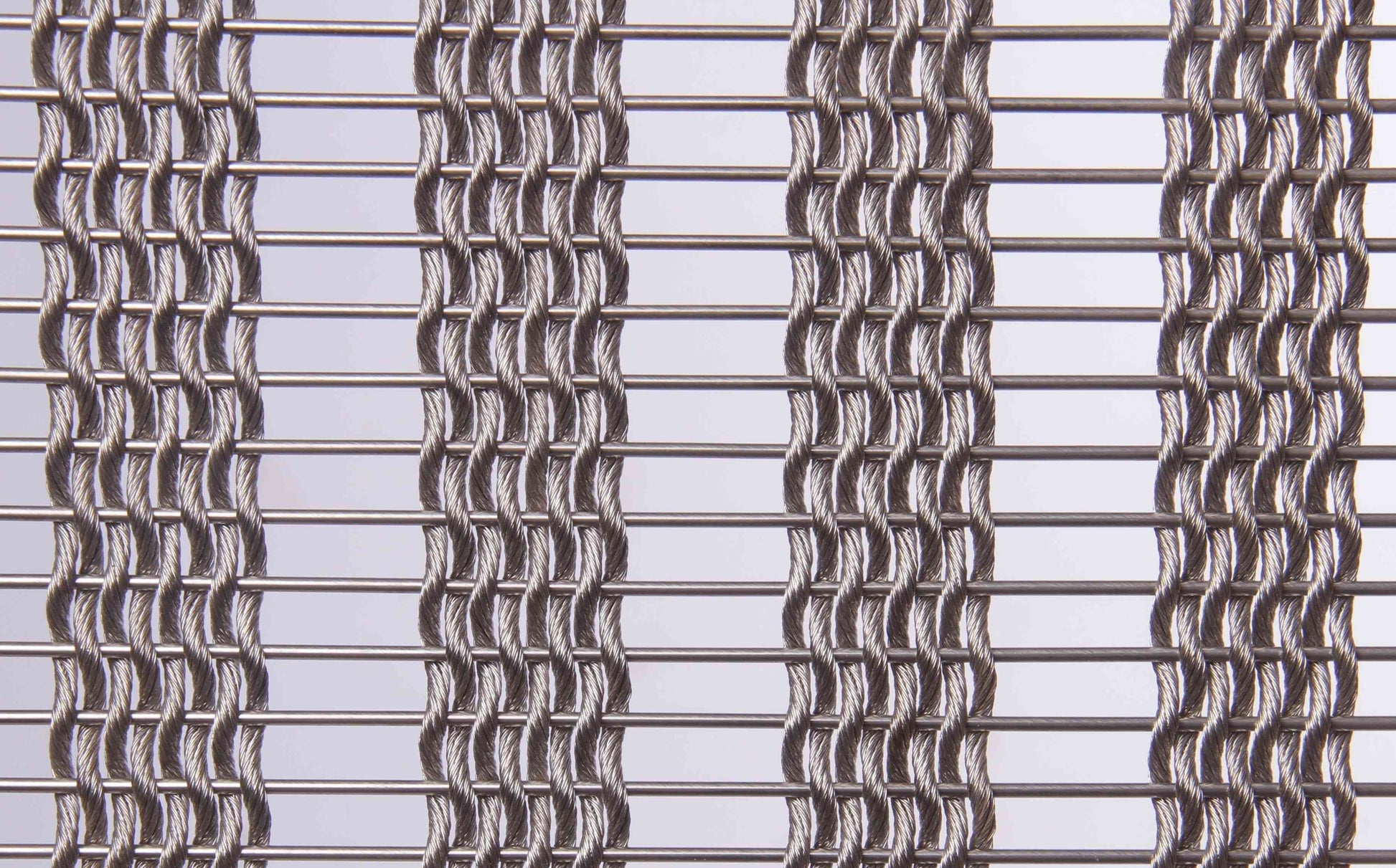 Close-up of a metal wire mesh with a grid pattern on a light gray background